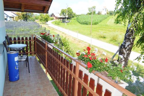 a balcony with flowers and a table and a fence at Gostilna s prenocisci Danica in Slovenska Bistrica