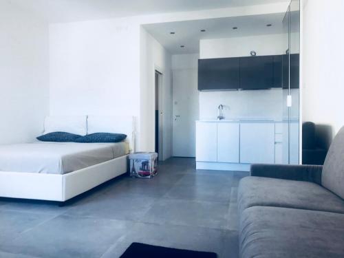 a white bedroom with a bed and a couch at appartamento piazza mazzini in Lido di Jesolo