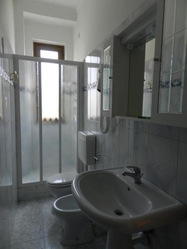a bathroom with two toilets and a sink and mirror at Hotel Air Palace Lingotto in Turin