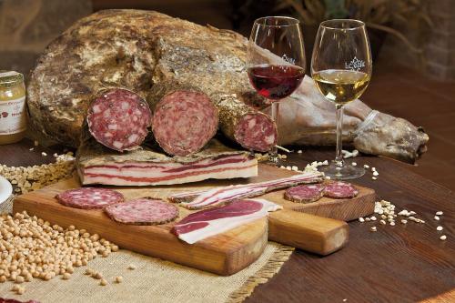 a table with a sandwich and two glasses of wine at Agriturismo Le Calle in Cinigiano