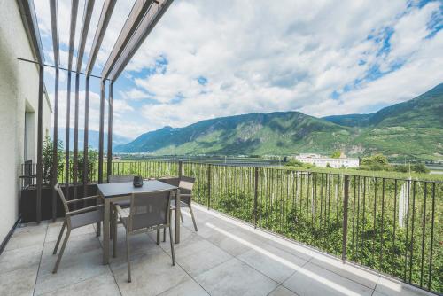 a balcony with a table and chairs and mountains at Sinnergut in Nalles