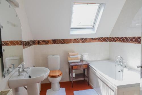 a bathroom with a tub and a toilet and a sink at Shearwater in Bridlington
