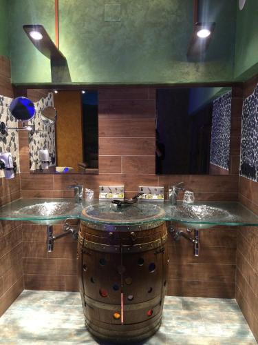 a bathroom with a barrel sink and a large mirror at Hotel SPA El Lagar de Isilla in La Vid y Barrios