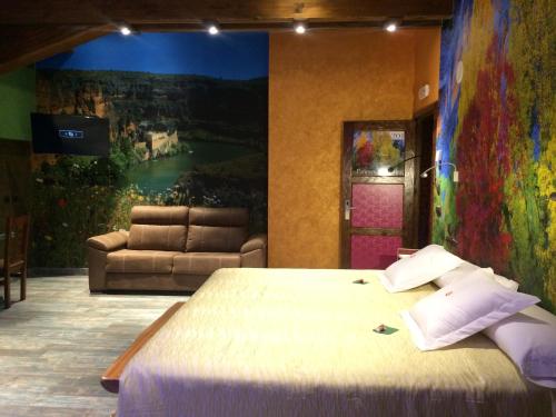 a bedroom with a bed and a painting on the wall at Hotel SPA El Lagar de Isilla in La Vid y Barrios