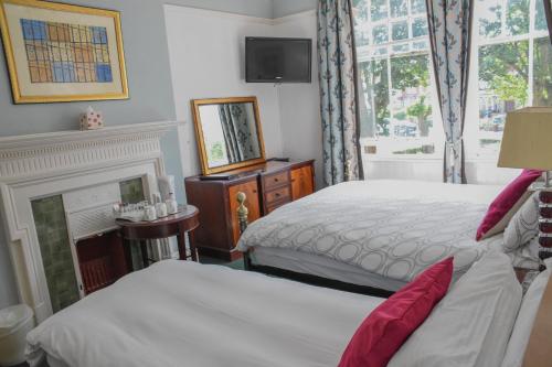a hotel room with two beds and a fireplace at Shearwater in Bridlington