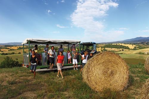 a group of people standing next to a pile of hay at Agriturismo Le Calle in Cinigiano