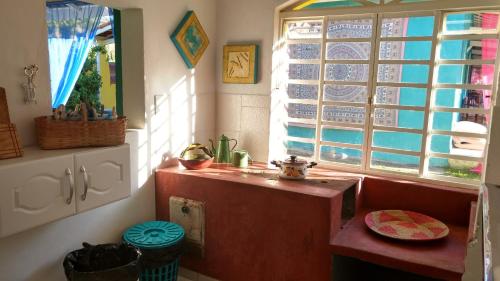 uma cozinha com um lavatório e uma janela em Casa da Yolanda - Hospedaria em São Francisco Xavier