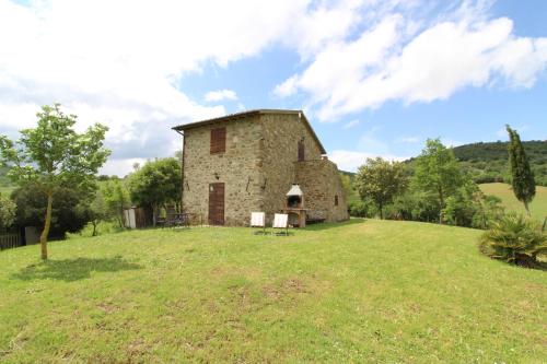 an old stone building on a grassy field at Agriturismo Le Calle in Cinigiano