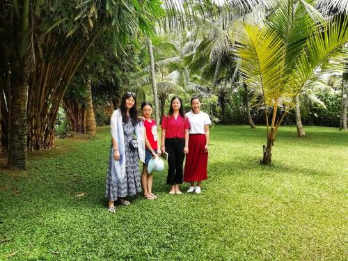 a group of three women standing in the grass at Old Parkland Hostel in Galle