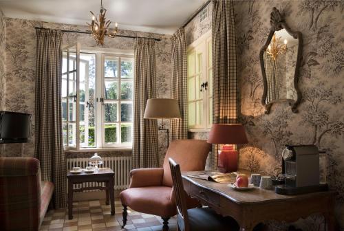 a living room with a table and a chair at Relais & Chateaux Hotel Landgoed Het Roode Koper in Ermelo