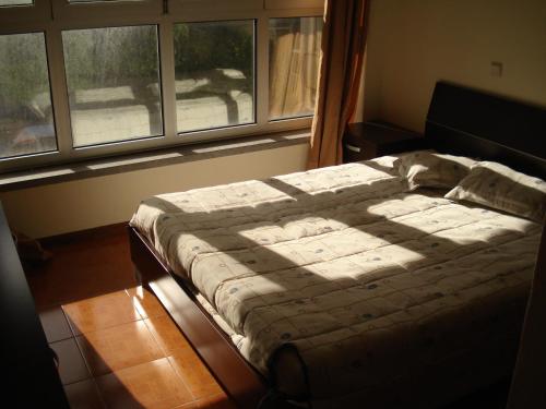 een bed in een slaapkamer met een raam bij Apartamento T1 - 3min do Santuário in Fátima
