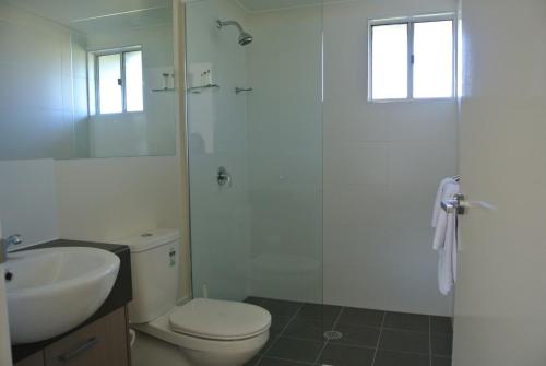 a bathroom with a toilet a sink and a shower at Dooley's Tavern & Motel Springsure in Springsure