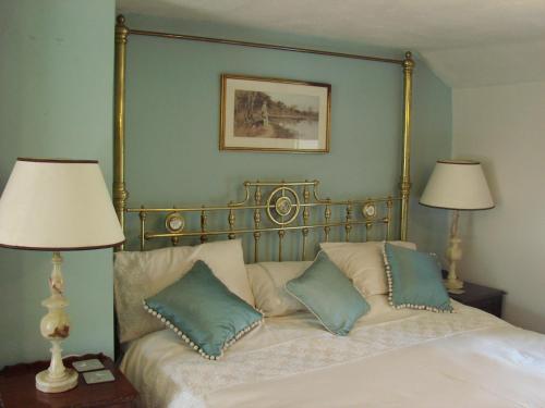 una camera da letto con un letto con cuscini e due lampade di Chapel Cottage Clitheroe Road a Waddington