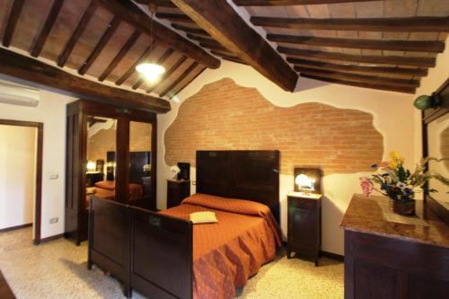a bedroom with a bed and a brick wall at Agriturismo Le Calle in Cinigiano