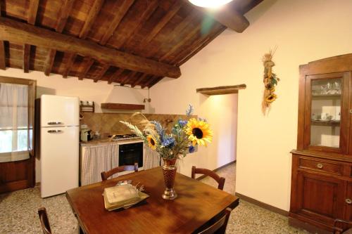 a kitchen with a table with a vase of flowers on it at Agriturismo Le Calle in Cinigiano
