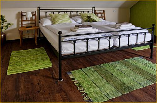 a bedroom with a bed with two rugs on the floor at Statek česká lípa Myslovice in Klatovy