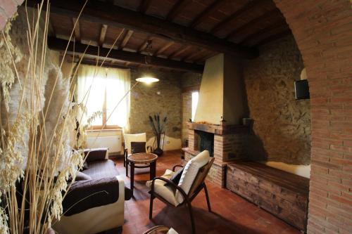 a living room with a fireplace and a brick wall at Agriturismo Le Calle in Cinigiano