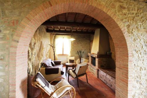 a living room with an archway in a stone wall at Agriturismo Le Calle in Cinigiano