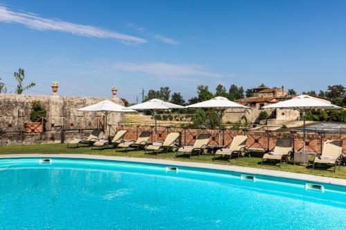 a swimming pool with chairs and umbrellas at Hotel Mulino di Firenze - WorldHotels Crafted in Florence