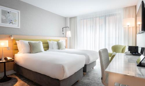 a hotel room with two beds and a desk at The Morgan Hotel in Dublin