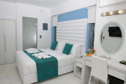 a bedroom with a bed and a mirror and a sink at Hellas Beach Hotel in Skaleta