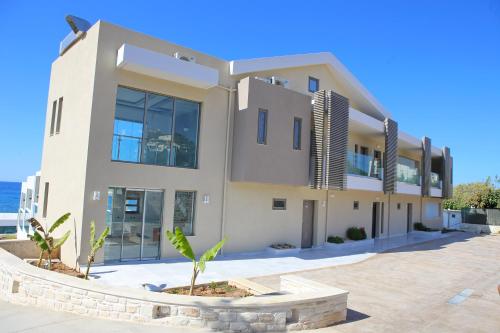 a large white house with a palm tree in front of it at Hellas Beach Hotel in Skaleta