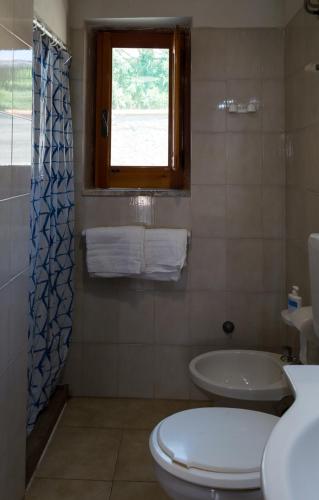 a bathroom with a toilet and a sink and a window at Casa Volcanalia in Vulcano