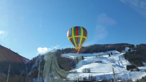 a hot air balloon flying over a snow covered mountain at Haus Silvia Kraml in Schladming