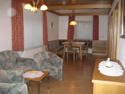 een woonkamer met een bank en een tafel en stoelen bij Haus Kaiser in Passriach