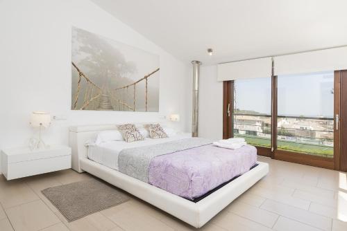 Un dormitorio blanco con una cama y una ventana grande. en Picara, en Mancor del Valle