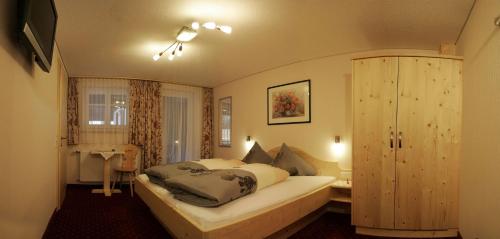 a bedroom with a large bed in a room at Pension Backstuba in Partenen