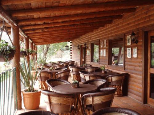 a restaurant with tables and chairs on a porch at Sierra Paraiso Hotel in Mazamitla