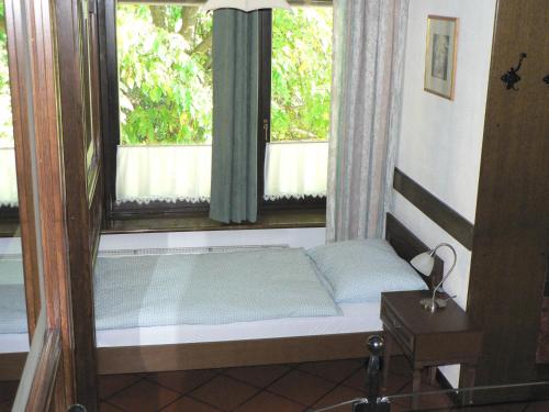 a bed in a room with two windows at Apartmaji Mak in Jesenice