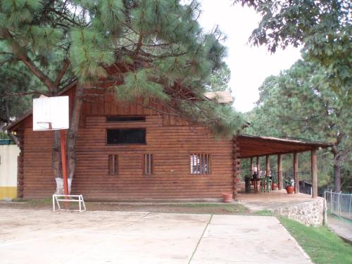 a log cabin with a basketball hoop in front of it at Sierra Paraiso Hotel in Mazamitla
