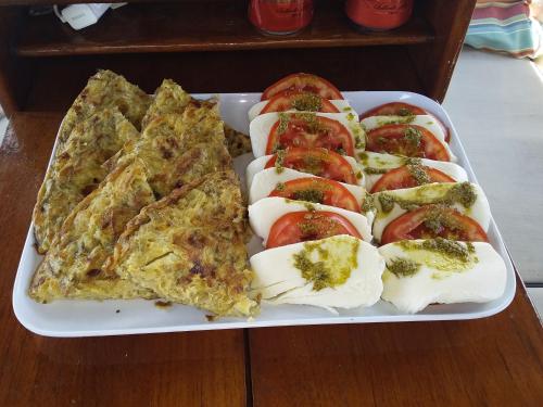 a tray of pizza and tomatoes on a table at Play to Live San Blas in El Porvenir