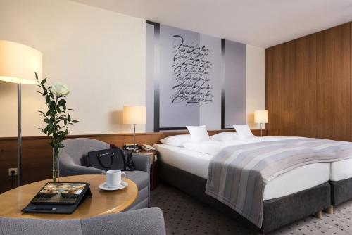 a hotel room with a bed and a table with a table at Maritim Airport Hotel Hannover in Hannover