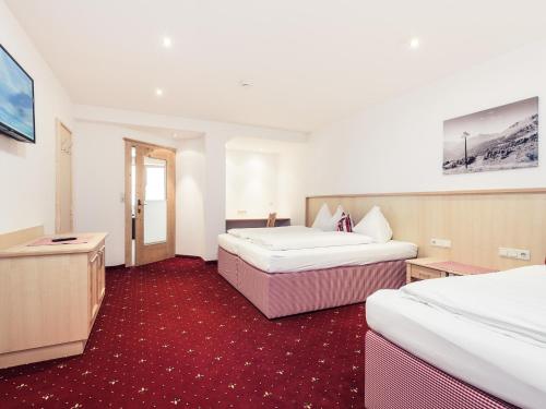 a hotel room with two beds and a tv at Leni Mountain Appartements in Sölden