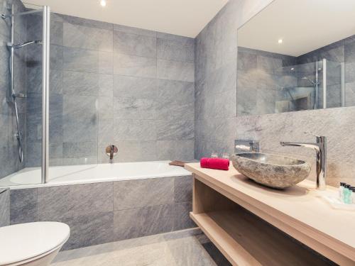 a bathroom with a tub and a sink and a bowl sink at Leni Mountain Appartements in Sölden