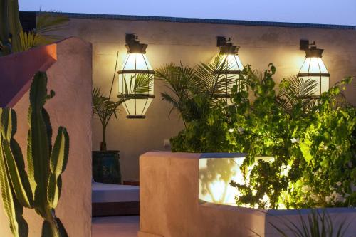 a room with a bunch of potted plants and lights at Dar Kandi in Marrakech