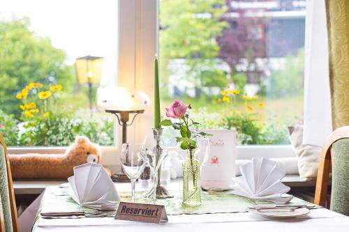 a table with a vase of flowers on a table with a window at Hotel Diana in Feldberg