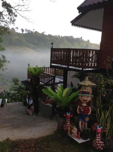 a statue of a person standing in front of a house at Klongsai Hills in Wang Nam Khieo