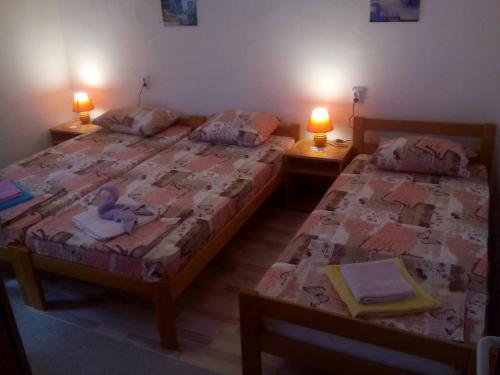 two twin beds in a room with two lamps at Guest House Vila Banjica in Pirot
