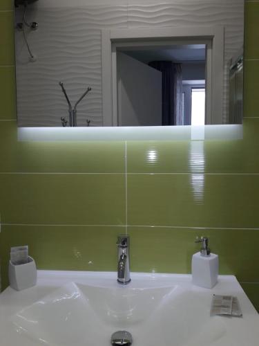 a bathroom sink with a large mirror above it at Bed Nonnonino in Porto Cesareo