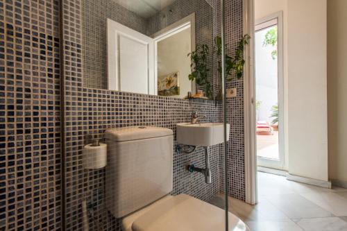 a bathroom with a toilet and a sink at Singular Pilatos in Seville