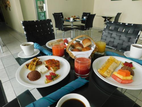 una mesa con dos platos de comida y bebida para el desayuno en Hotel San Jose Hostal, en San Salvador