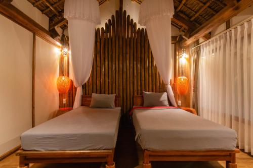 two beds in a room with a large organ at Puluong Home in Pu Luong