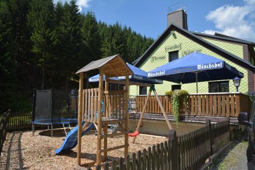 a playground with a slide and an umbrella at Gasthof Thomas Müntzer in Steinheid
