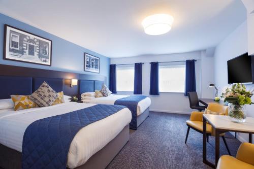 a hotel room with two beds and a tv at Temple Bar Hotel Dublin by The Unlimited Collection in Dublin