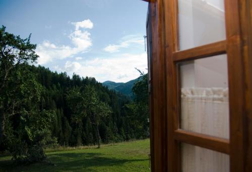 a view from a window of a field and mountains at Apartment ''Planinsko selo'' in Zaovine