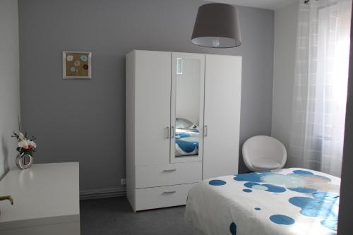 - une chambre avec une armoire blanche et un lit dans l'établissement Appartement T3 très calme - Le Bartholdi - Centre de Colmar, à Colmar